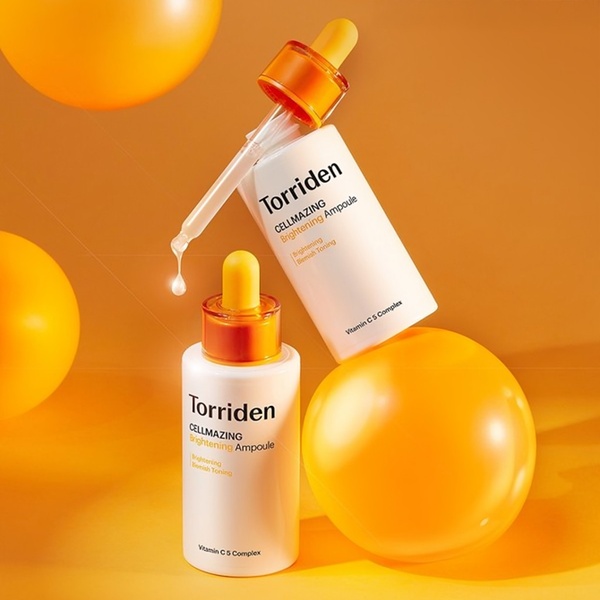 A clean, high-contrast studio shot of two brightening ampoule bottles with floating yellow spheres, emphasizing a premium and fresh brand aesthetic.